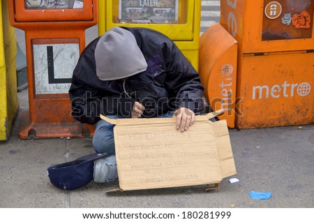 NEW YORK, USA OCTOBER 28: A homeless man sleeping beside newpaper boxes on Oct 28, 2013 in Manhattan, New York, USA. In New York city total number of homeless people in municipal shelters: 52,351