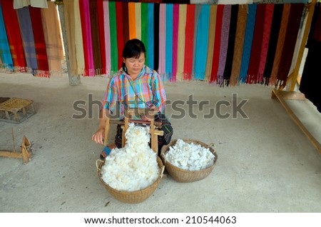 LUANG PRABANG LAOS MARCH 29: Unidentified woman prepare cotton fibers on march 29 2013 in Luang Prabang Laos. People of the Phu-Tai ethnic group have a long standing tradition of cotton production.