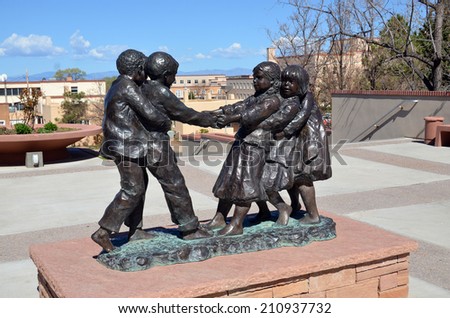 SANTA FE, NM USA APRIL 21: Bronze sculpture of three girls and two boys playing tug o\' war (without a rope) on april 21, 2014 in Santa Fe, NM. Glenna Goodacre Lubbock, Texas, 1939, American sculptress