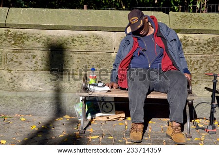 NEW YORK, USA OCTOBER 28: A homeless man sleeping on bench park on Oct 28, 2013 in Manhattan, New York, USA. In New York city total number of homeless people in municipal shelters: 52,351