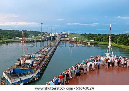 PANAMA CANAL - NOV 7:  Tourists stand on bow of cruise ship as it enters first lock of Panama Canal on November 7, 2009 in Panama Canal.