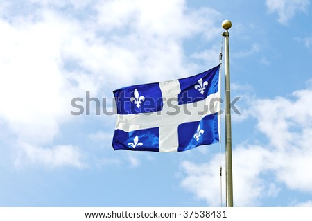 Flag of Quebec against the blue sky.