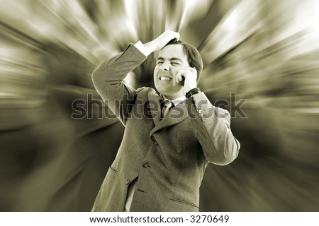 Worried, freaked-out business man pulling his hair while yelling at a cell phone.