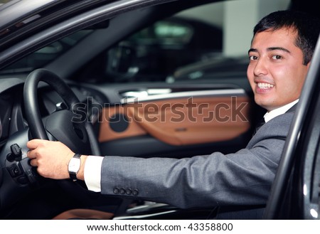 happy asian businessman driving a luxurious car
