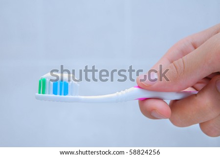 hand holding tooth brush with paste on it