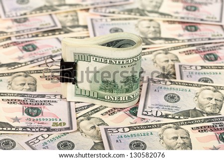Folded hundred dollar bill on money background