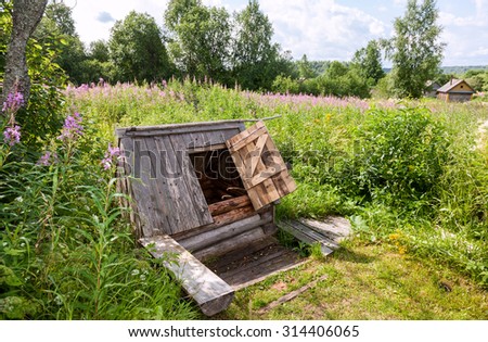 Old village wooden water well in summer day