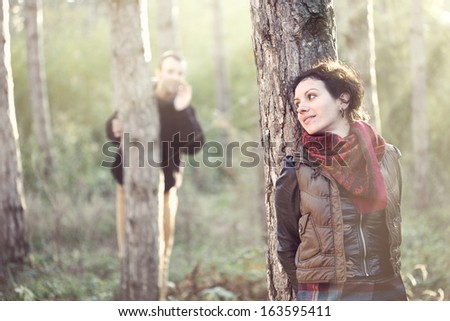 Enamoured man looking for his girlfriend and calling her in the forest in the sunlight