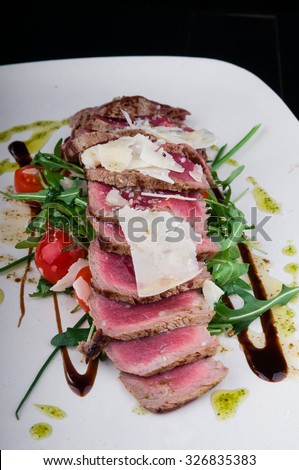 Medium rare steak served on a plate with vegetables and cheese