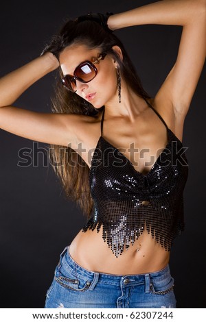 attractive brunette in denim skirt black top and sunglasses studio