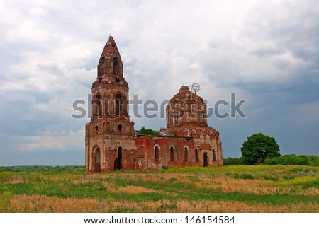 Neglected church on the empty field during dramatic rainy weather, Russia