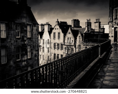 Black And White Image Of An Ancient Edinburgh Street Under A Stormy Sky
