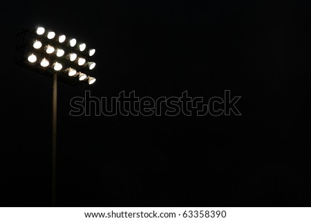 Stadium flood lights on a sports field at night with copy space