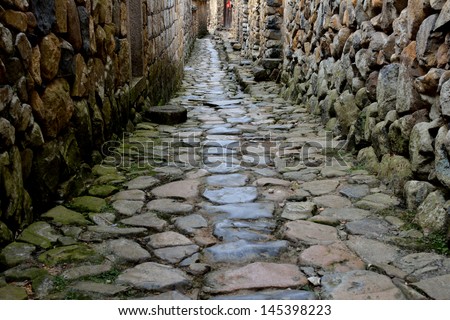 Small street extend, with stone wall and road