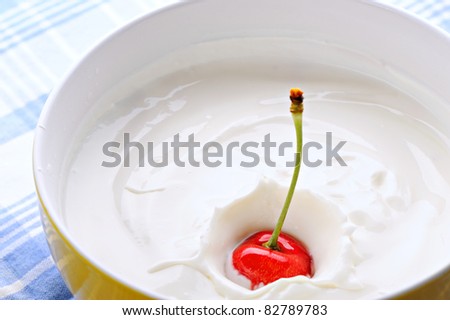 single red cherry in a bowl full with yogurt