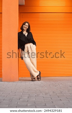 Image, Stock Photo Woman leaning against door in front of red wall