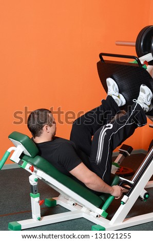 Man on training apparatus in sports club