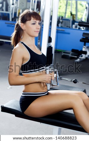 Woman on training apparatus in sports club
