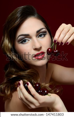 The beautiful woman with a sweet cherry