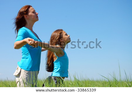 Friendship and happiness of mum and daughter against the blue sky