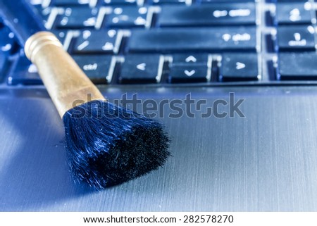 Computer cleaning brush on a laptop