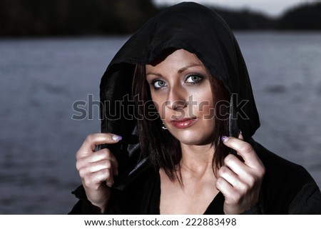 Woman in black hood out at night