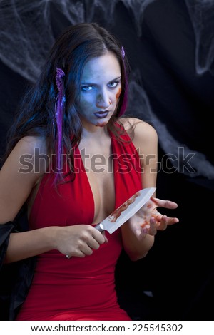 Foxy halloween woman or vampire with bloody knife