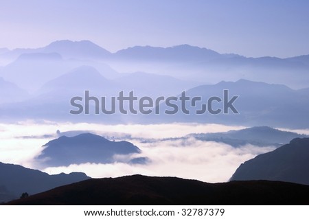 View of far away blue mountains in the fog in Asturias