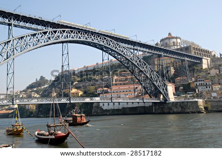 View of Porto city, Portugal. Porto city, excursion boat in the river Douro and the Bridge of Luis I with tram, Portugal.  It was made by design o? Gustaf Eiffel. Point of interest in Portugal.