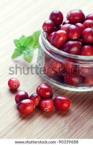 Cranberries in a glass jar, closeup shot, focus on the berries on the foreground