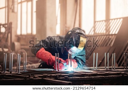 Similar – Image, Stock Photo welder is welding metal part in garage. with protective mask,