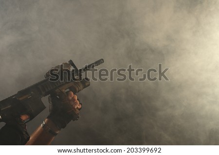 Automatic Rifle directed towards smoke-filled background