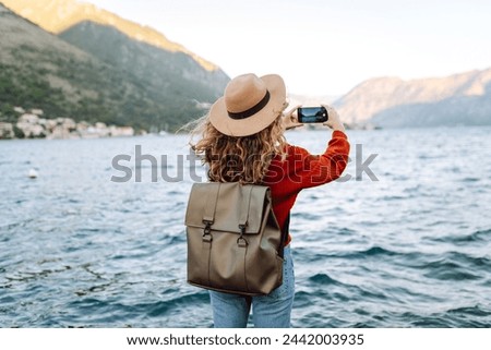 Similar – Image, Stock Photo Woman with backpack taking selfie on smartphone on background of mountains