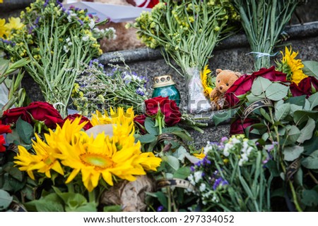 Kiev, Ukraine -  17 July 2015: People place flowers,  toys and light candles in commemoration of the victims of Malaysia Airlines MH17 plane accident in eastern Ukraine, in front of the Dutch embassy