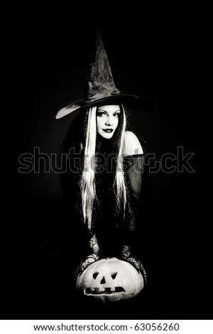 Halloween witch with a skull over black background with smoke