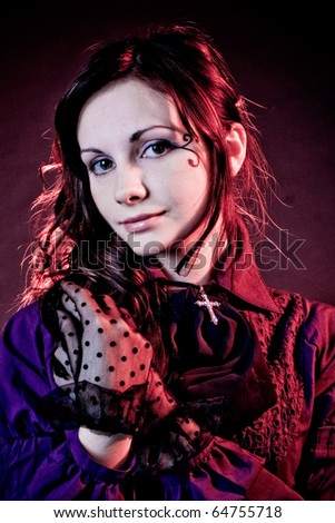 Portrait of a goth girl in a gray backgorund with red solar