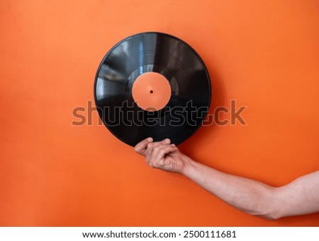 Similar – Image, Stock Photo Man holding vinyl record. Vintage music style. Rock style. Male wearing black jacket holding black disc standing on dark background. Retro music