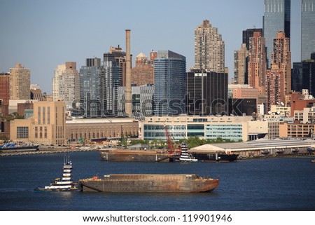 NEW YORK - APRIL 29: The Manhattan skyline with tugboat and barge on the Hudson River on April 29, 2012 in New York. First settled in 1624, New York City now has a population of over 8 million people.