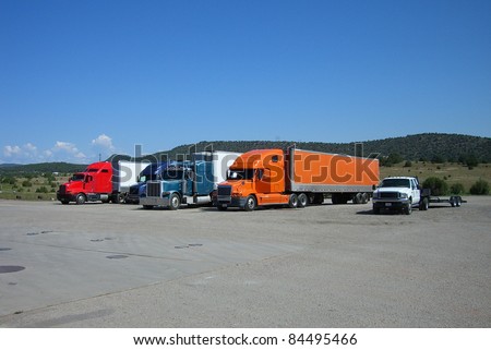 Truck Stop - Rigs lined up in a row at an interstate truckstop rest area.