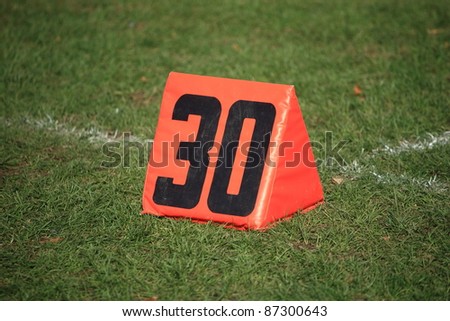 Football Field Yard Marker - Thirty 30 yard line on grass playing field.