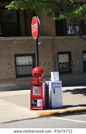 CHICAGO, ILLINOIS - APRIL 26: Chicago street scene with stop sign and Tribune newspaper stand on April 26, 2010. The Tribune was first published in 1847.