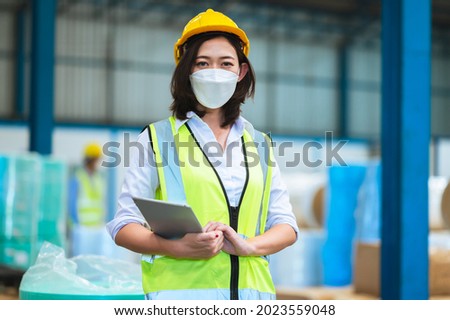 Team engineers and foreman wear a mask, hard hat, and vest. Standing consult discuss industrial production management. Explaining job details through laptops and tablets in factories or warehouses. Foto stock © 