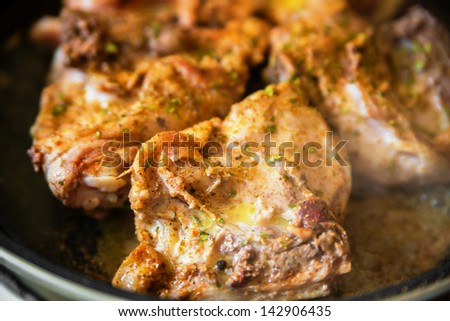 Chicken with spice on frying pan