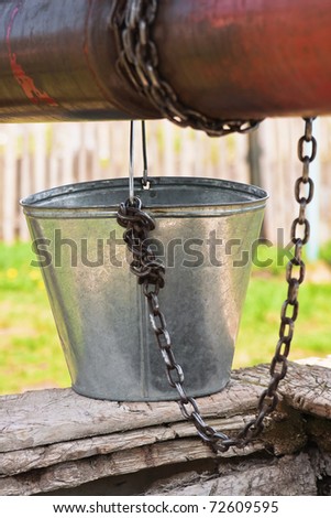 Empty pail, old chain and old well pulley