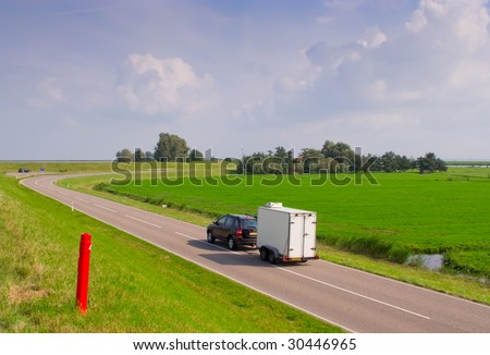 car-trailer traveling on the road to rural areas