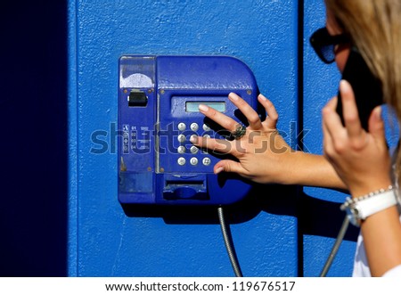 Woman dials for public pay phone outdoor