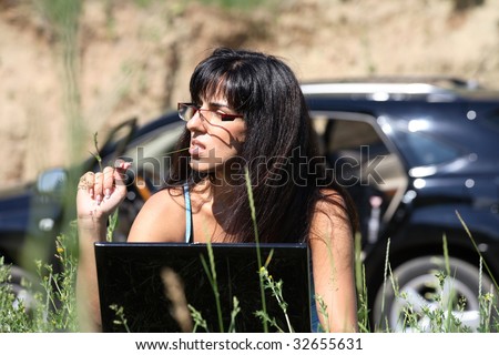 business woman with laptop on the nature and car on the background