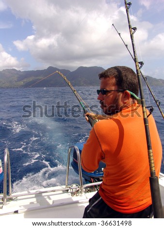 Fisherman fishing on boat in ocean on Seychelles