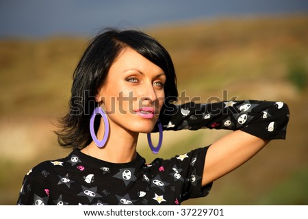 portrait of happy young woman with hands behind neck, nature