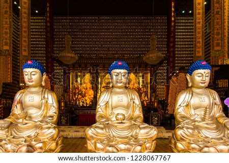 Row of three golden Buddha statues in main shrine of Ten Thousand Buddhas Monastery, Hong Kong, Sha Tin, New Territories Stok fotoğraf © 